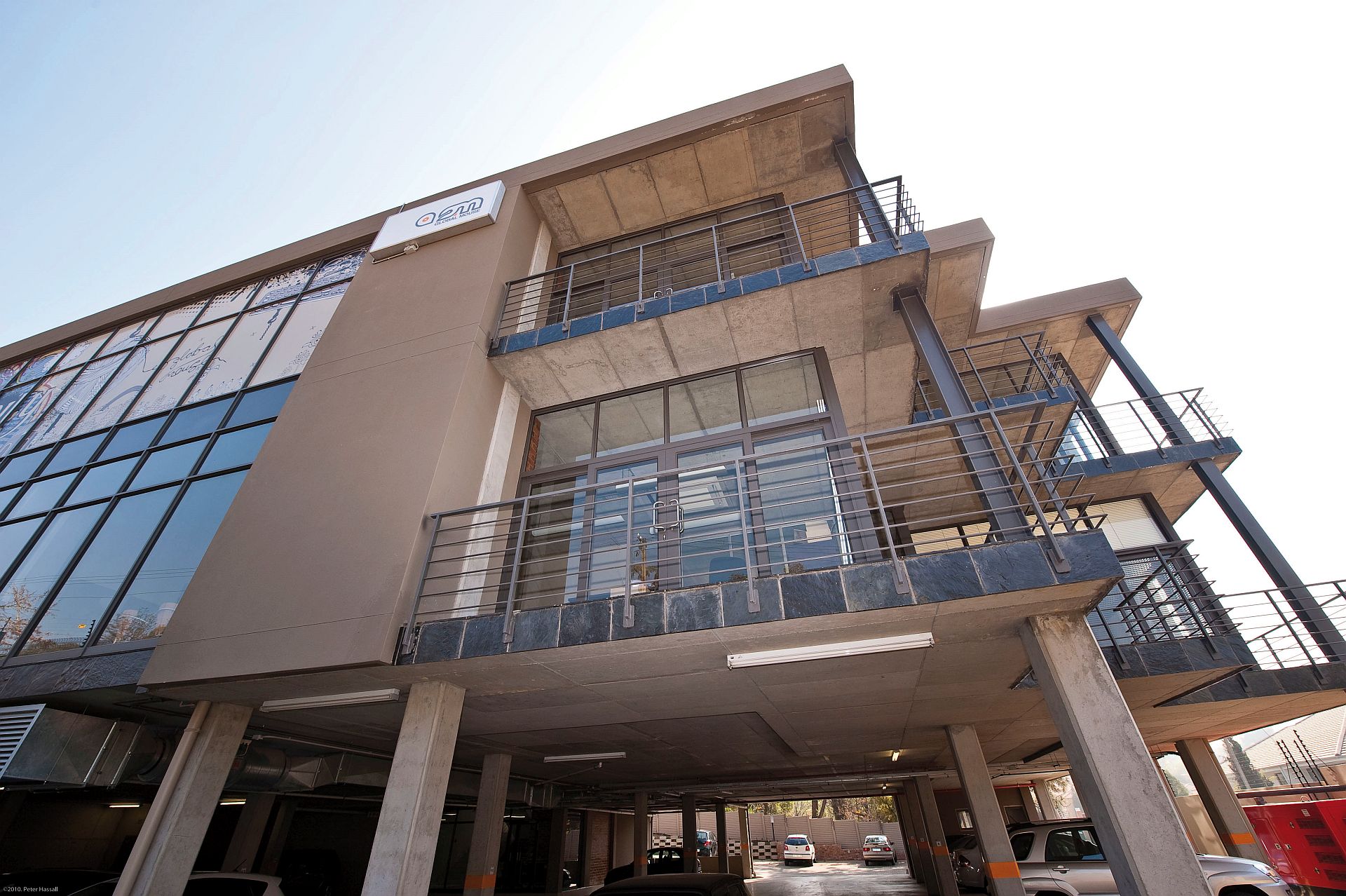 An RC Framed structure in Bryanston, Gauteng, a lot of which is exposed with the inclusion of structural steel columns, Large glazed façade to the one side and setback aluminium shopfronts to provide small balconies and a plaster feature panel going from first floor to roof (2 floors)